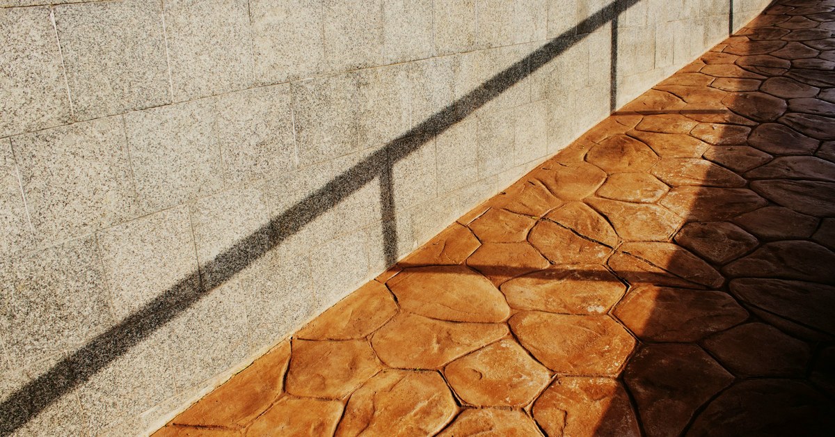 Flagstone-pattern stamped concrete walkway in warm terracotta tones